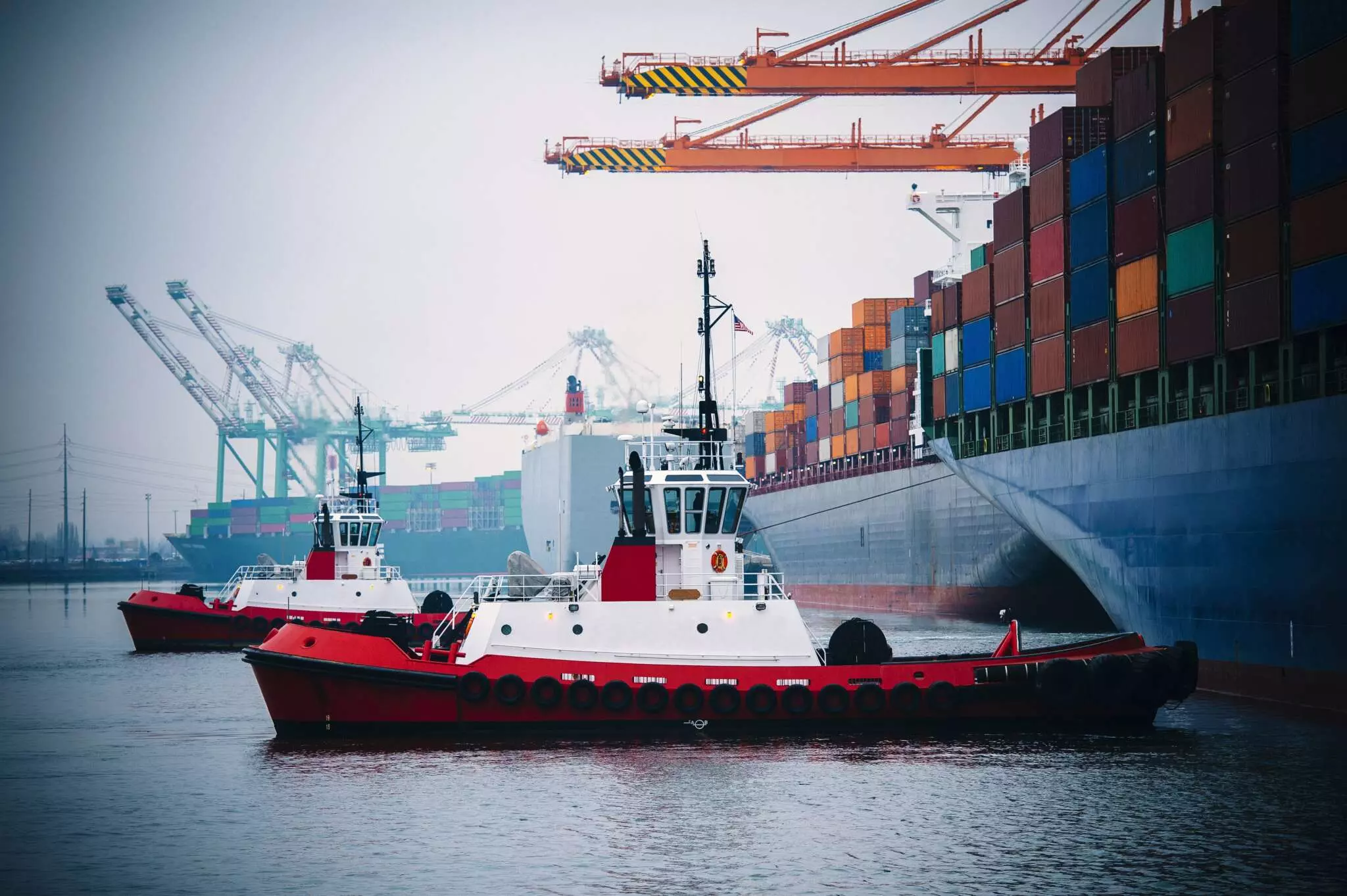 Container ship and cargo handling equipment in harbor