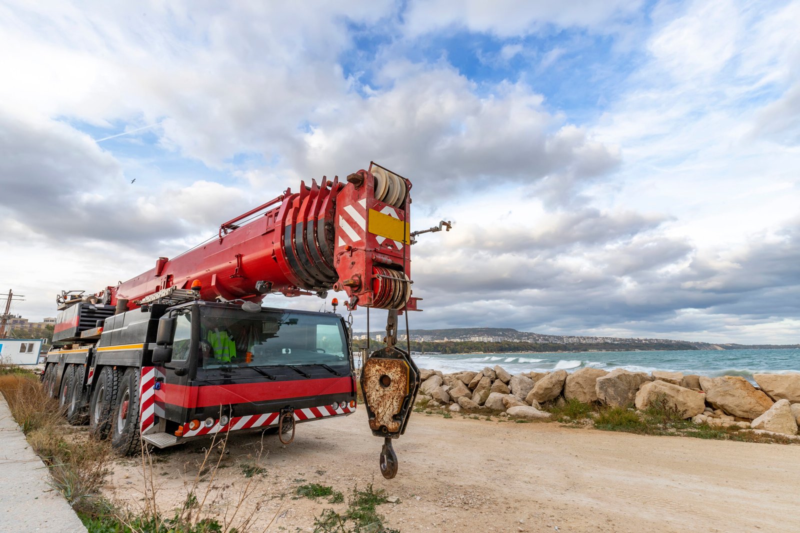 Heavy duty mobile crane parked near the sea. Telescopic truck mo Heavy duty mobile crane parked near the sea. Telescopic truck mounted crane
