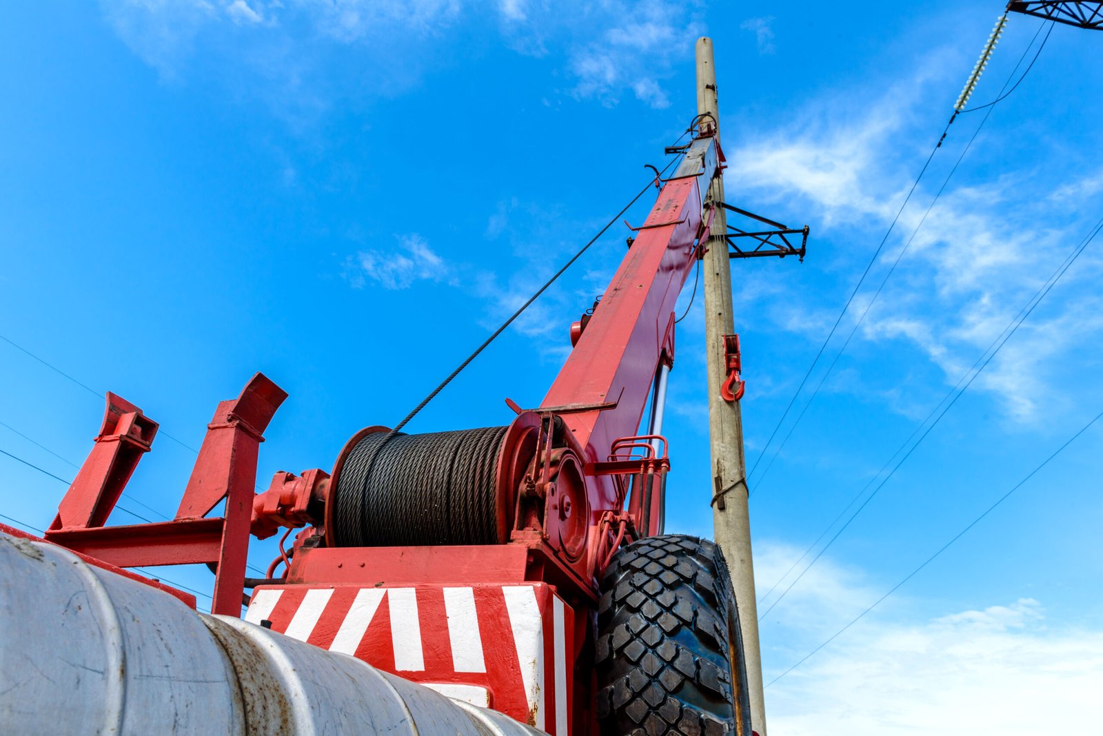Installation of column for high-voltage electricity line Installation of column for high-voltage electricity line against the background of blue sky on a sunny summer day