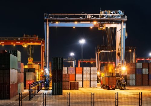 Industrial crane loading containers at a cargo terminal